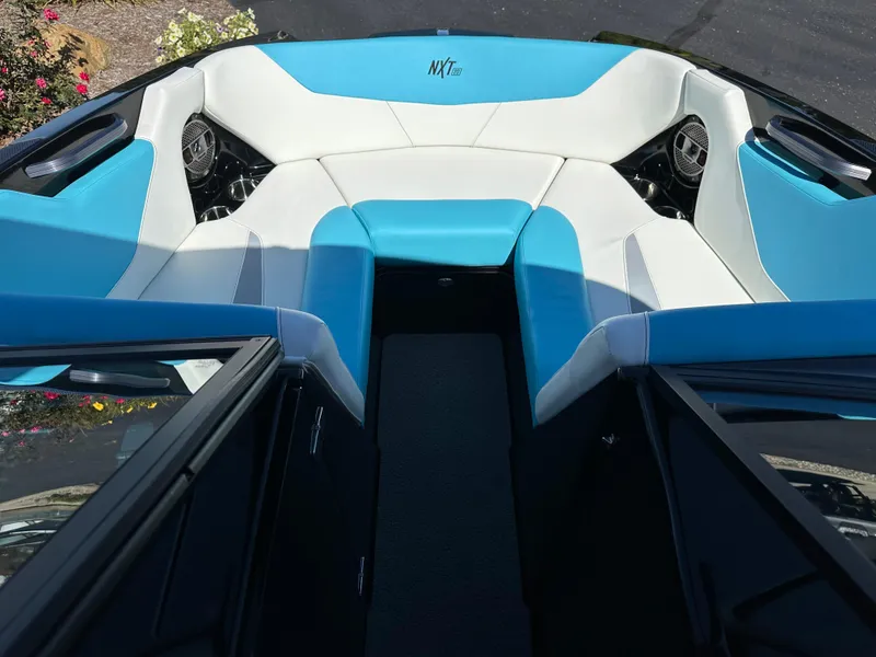 Slide: The Image of 2022 MasterCraft NXT20 boat interior with blue and white seating, featuring speakers. - 17