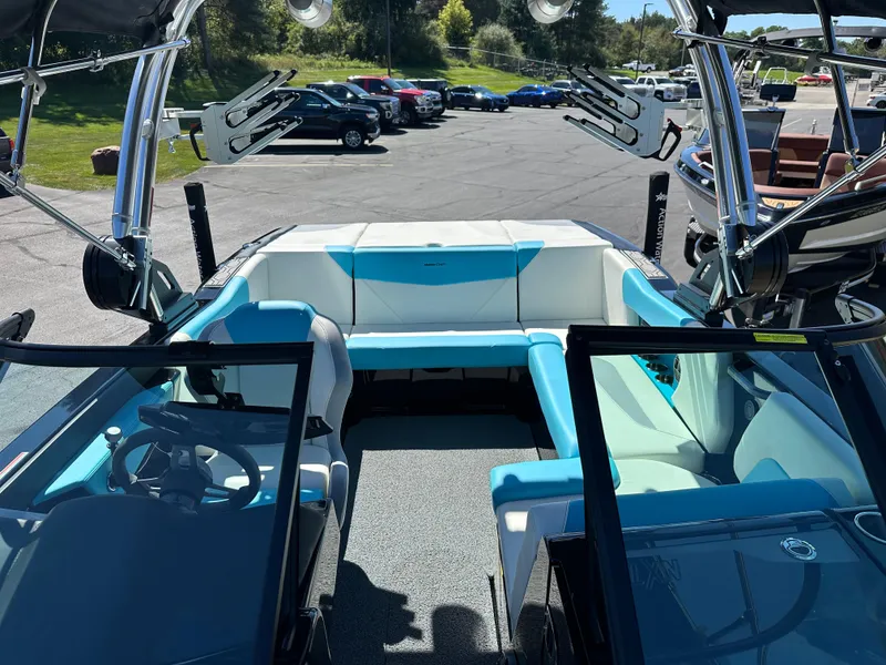 Slide: The Image of 2022 MasterCraft NXT20 boat interior with blue and white seating, parked outdoors. - 18