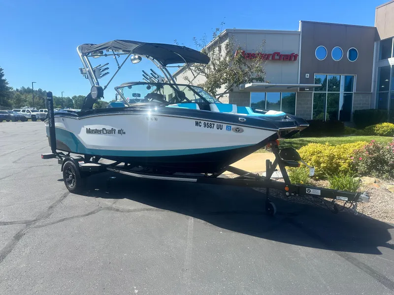 Slide: The Image of 2022 MasterCraft NXT20 boat on trailer outside dealership. - 2