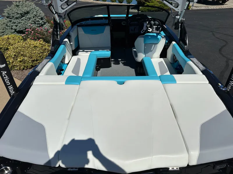 Slide: The Image of 2022 MasterCraft NXT20 boat interior with white and blue seating, parked outdoors. - 8