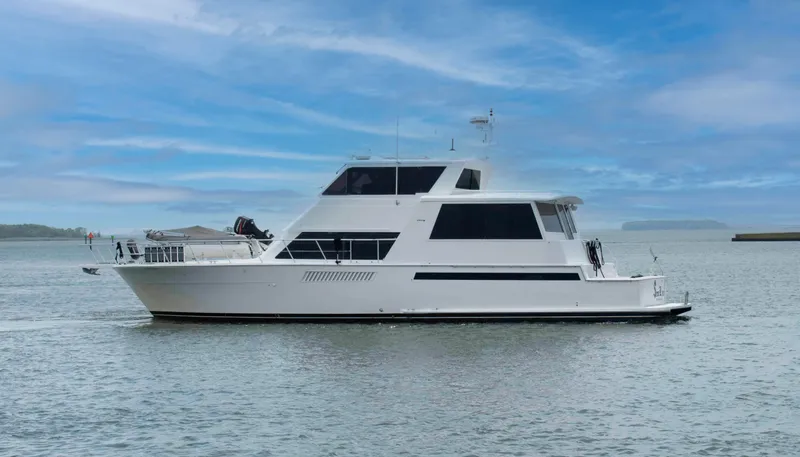 The Image of 1999 Viking 60 Cockpit Motor Yacht on calm water under a clear blue sky. - 0