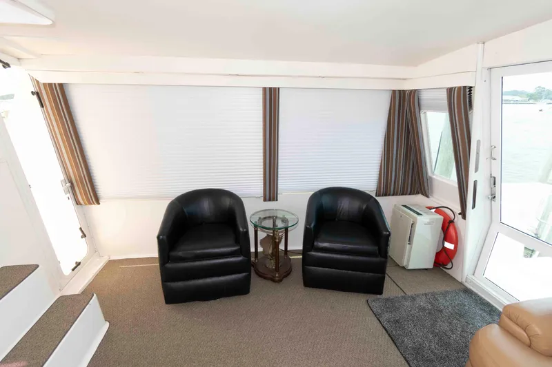 Slide: The Image of Interior of 1999 Viking 60 Cockpit Motor Yacht with two black chairs and a glass table. - 12