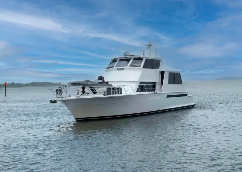 Slide: The Image of 1999 Viking 60 Cockpit Motor Yacht on calm water under a blue sky. - 2