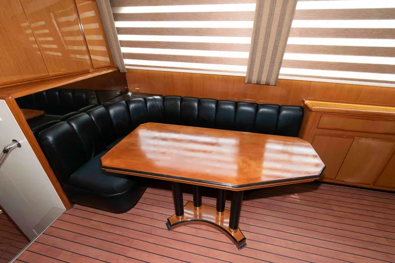 Slide: The Image of Interior of 1999 Viking 60 Cockpit Motor Yacht with wooden table and leather seating. - 28