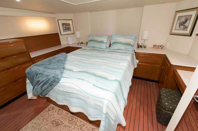 Slide: The Image of Cozy bedroom in 1999 Viking 60 Cockpit Motor Yacht with striped bedding and wooden accents. - 31