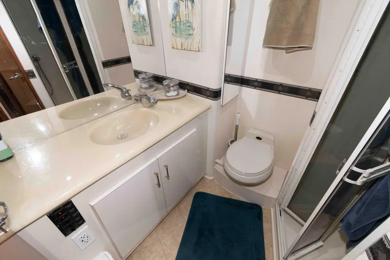 Slide: The Image of Bathroom interior of 1999 Viking 60 Cockpit Motor Yacht with dual sinks and shower. - 33