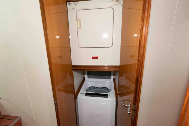 Slide: The Image of Laundry area with stacked washer and dryer in 1999 Viking 60 Cockpit Motor Yacht. - 38