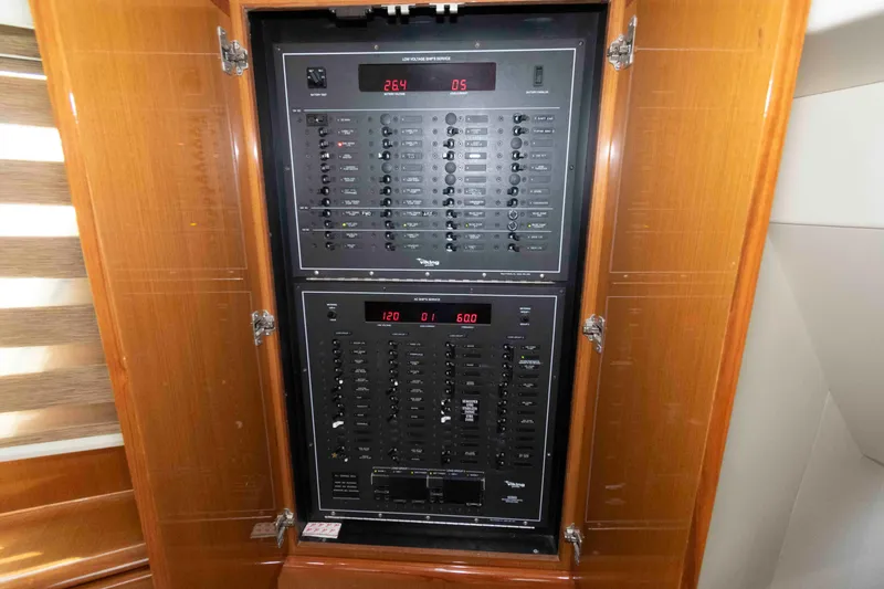 Slide: The Image of Electrical panel inside 1999 Viking 60 Cockpit Motor Yacht, featuring control switches and digital displays. - 39