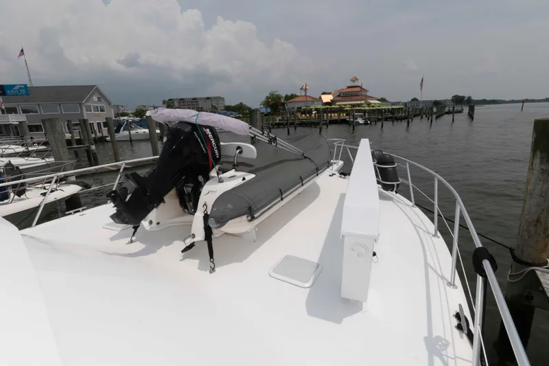 Slide: The Image of 1999 Viking 60 Cockpit Motor Yacht with dinghy on deck, docked at marina. - 6