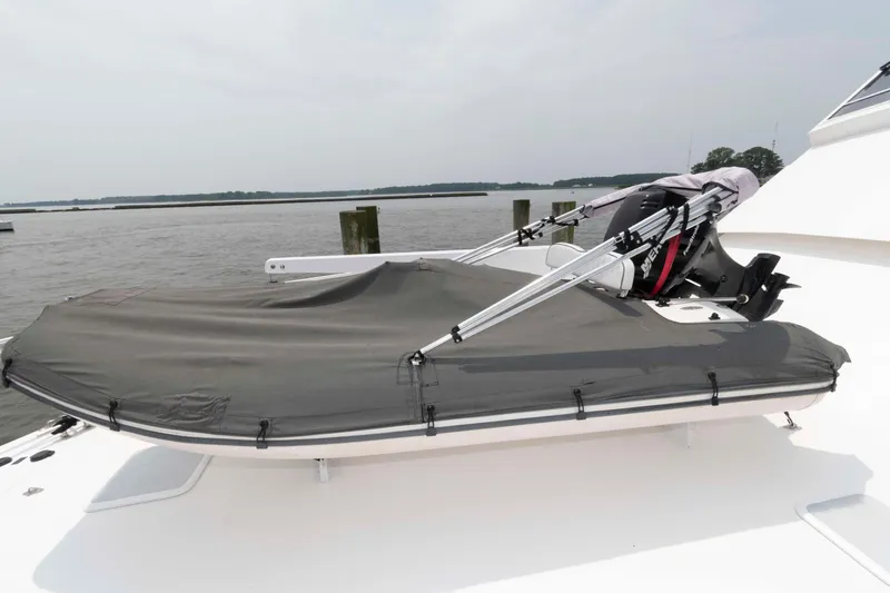 Slide: The Image of 1999 Viking 60 Cockpit Motor Yacht with covered deck and equipment, docked by the water. - 7