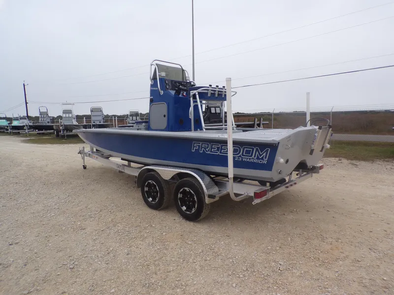 Slide: The Image of 2025 Freedom Warrior 23 boat on trailer, parked outdoors. - 12