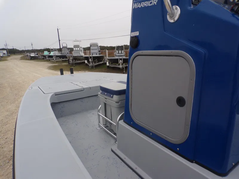 Slide: The Image of 2025 Freedom Warrior 23 boat, blue console, docked on a gravel path. - 18