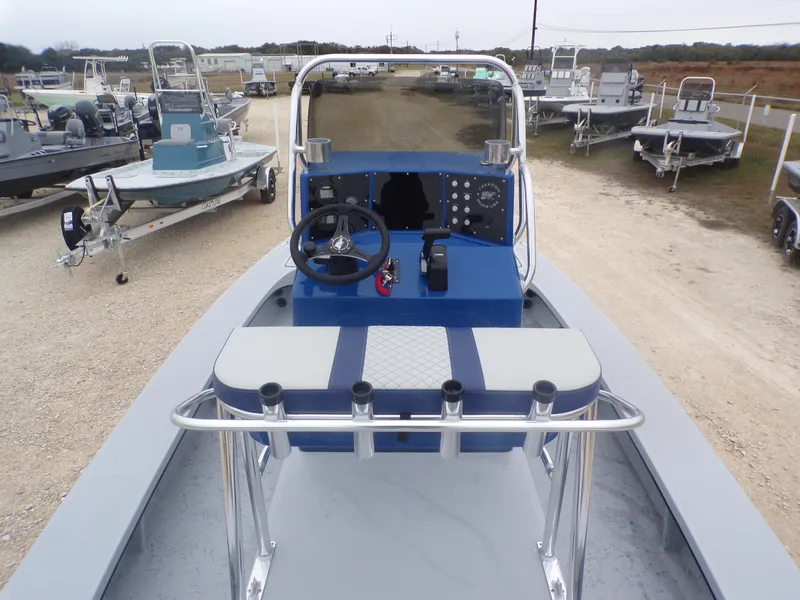 Slide: The Image of 2025 Freedom Warrior 23 boat with blue console and seating, displayed outdoors. - 22