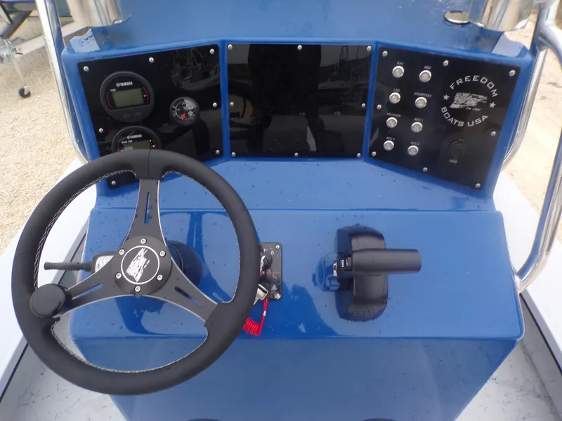 Slide: The Image of Control panel of 2025 Freedom Warrior 23 boat with steering wheel and gauges. - 24