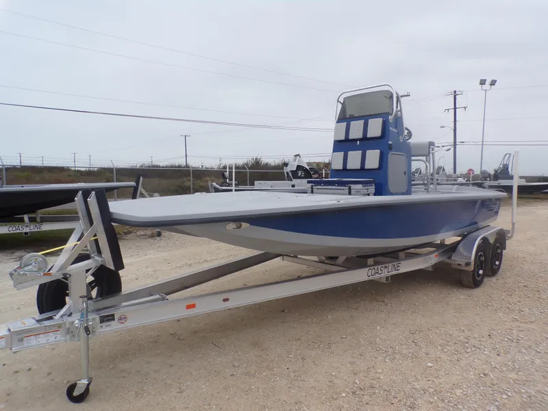 Slide: The Image of 2025 Freedom Warrior 23 boat on trailer, blue and gray design, parked outdoors. - 3