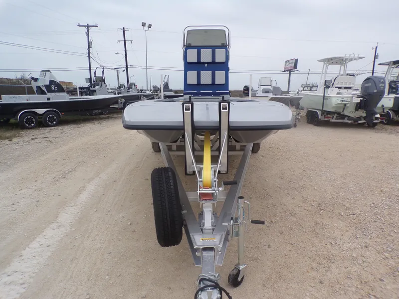 Slide: The Image of 2025 Freedom Warrior 23 boat on trailer in a gravel lot, surrounded by other boats. - 5