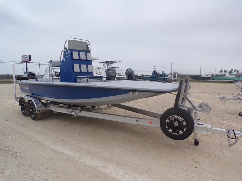 Slide: The Image of 2025 Freedom Warrior 23 boat on trailer, blue and gray design, parked outdoors. - 7