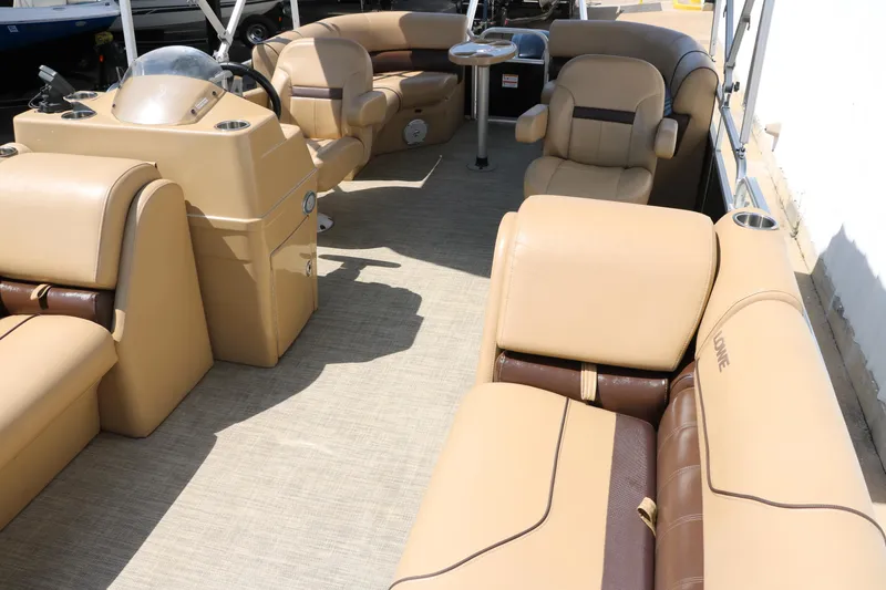 Slide: The Image of 2019 Lowe SS210 pontoon boat interior with tan seating and steering console. - 17