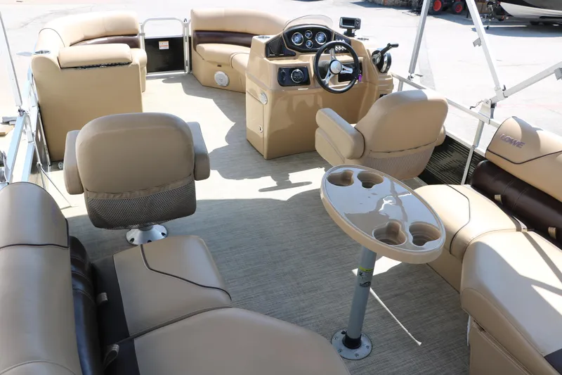 Slide: The Image of 2019 Lowe SS210 pontoon boat interior with beige seating and steering console. - 21