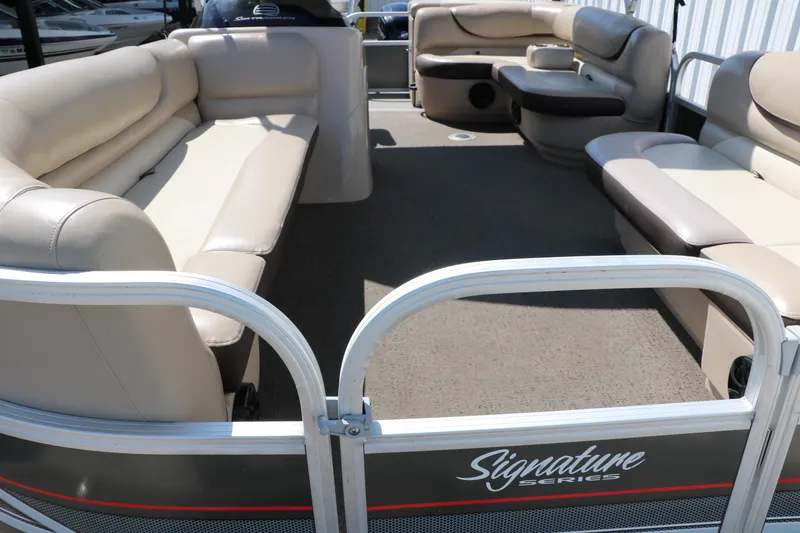 Slide: The Image of 2015 Sun Tracker Party Barge 20 DLX interior with beige seating and spacious layout. - 14