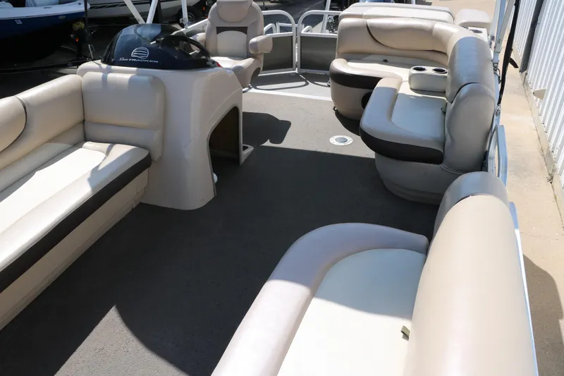 Slide: The Image of 2015 Sun Tracker Party Barge 20 DLX interior with beige seating and steering console. - 15