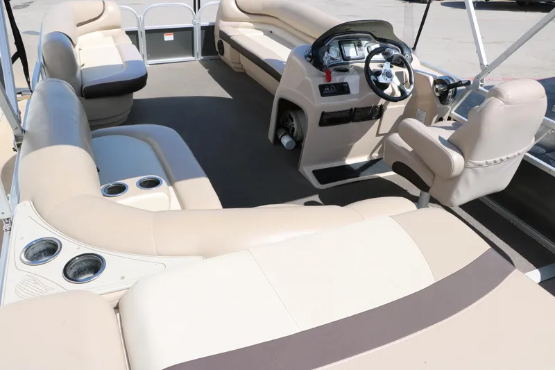Slide: The Image of 2015 Sun Tracker Party Barge 20 DLX interior with beige seating and steering console. - 18