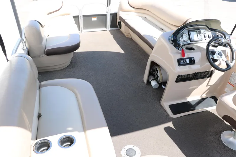 Slide: The Image of 2015 Sun Tracker Party Barge 20 DLX interior with beige seating and steering console. - 22