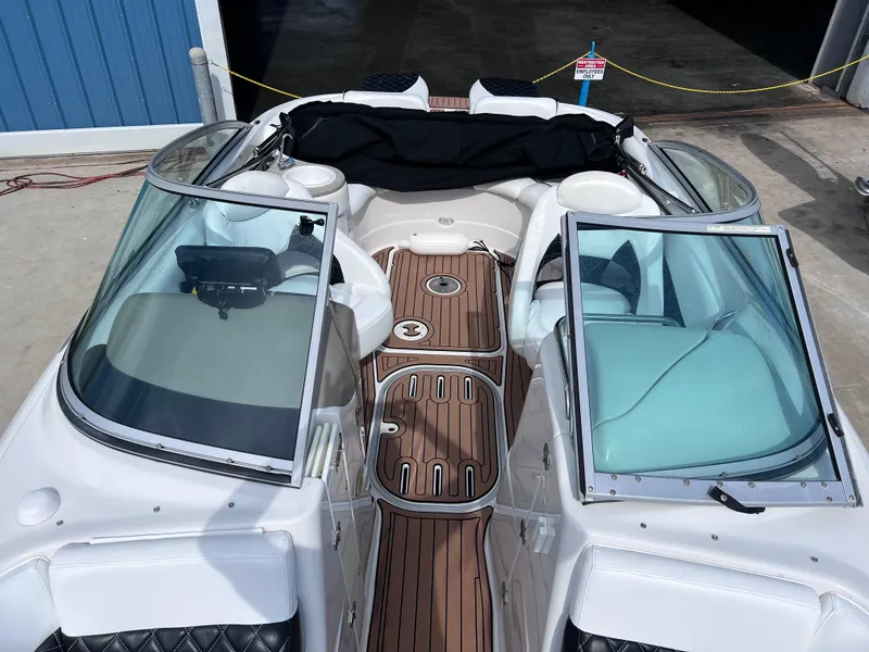 Slide: The Image of 2004 Four Winns 240 Horizon boat with open cockpit and wood-style flooring. - 14