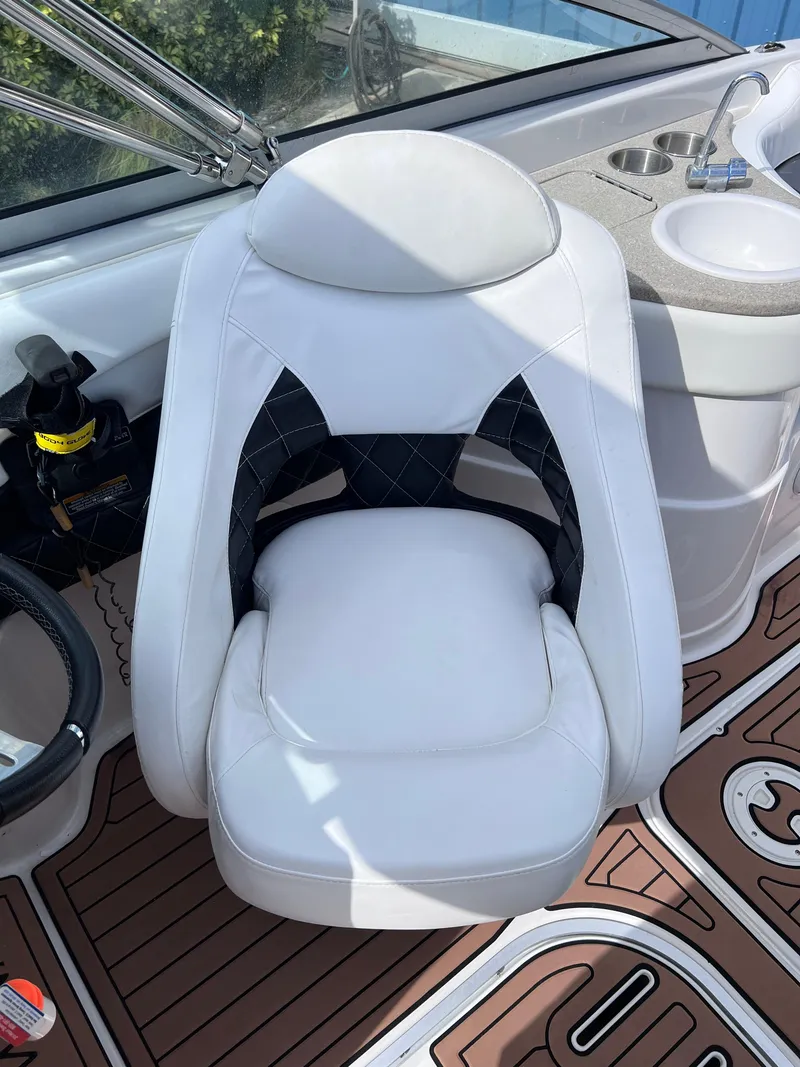 Slide: The Image of 2004 Four Winns 240 Horizon boat interior with white captain's chair and dashboard. - 16