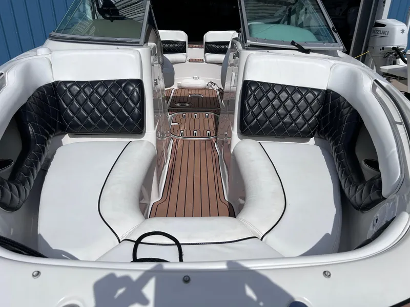 Slide: The Image of 2004 Four Winns 240 Horizon boat interior with white and black quilted seating, wooden flooring. - 20