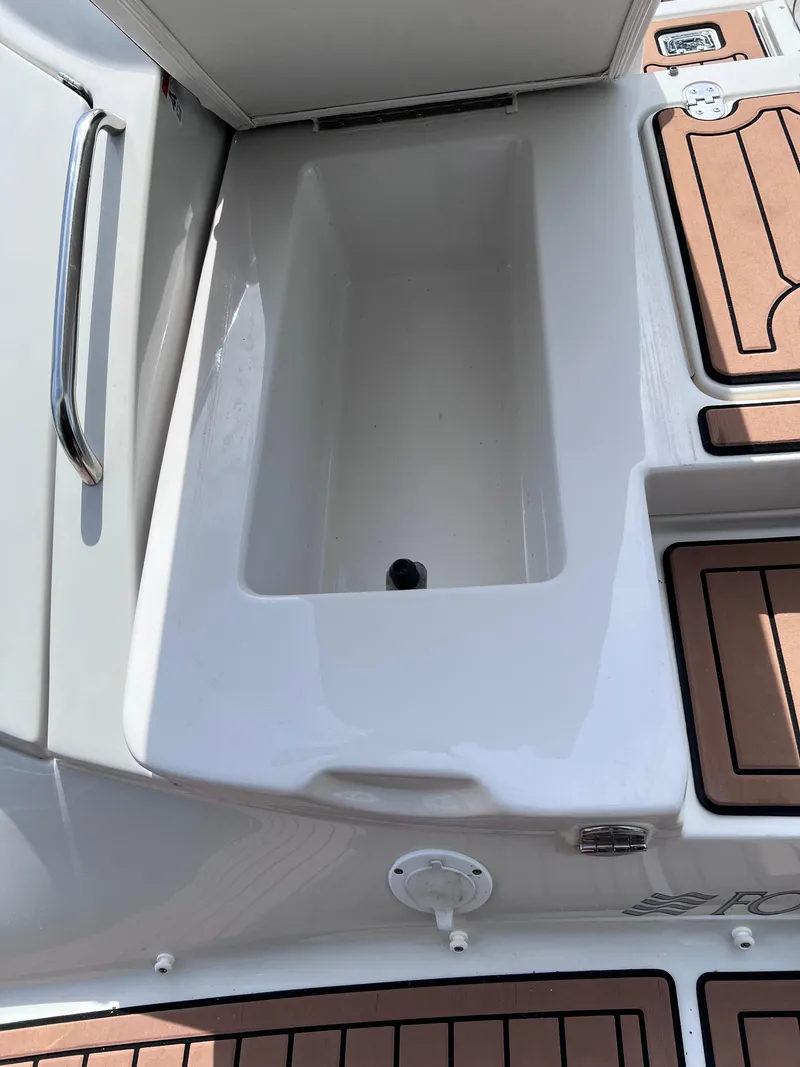 Slide: The Image of 2004 Four Winns 240 Horizon boat interior with storage compartment and teak flooring. - 21