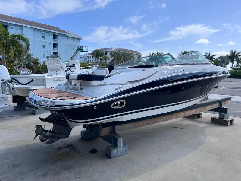 Slide: The Image of 2004 Four Winns 240 Horizon boat on display, docked outdoors under a clear blue sky. - 4
