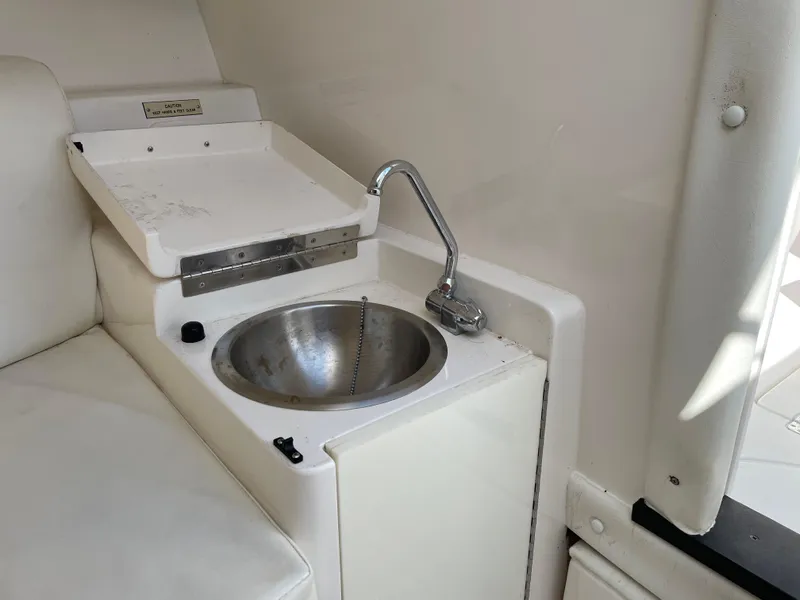 Slide: The Image of Compact sink area in 2008 Intrepid 323 Cuddy boat interior. - 23