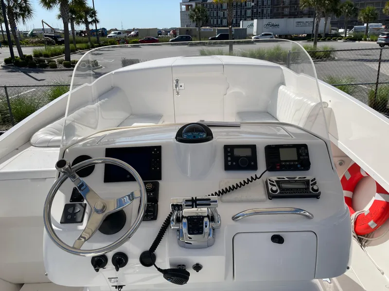 Slide: The Image of 2008 Intrepid 323 Cuddy boat dashboard with steering wheel, navigation controls, and safety equipment. - 28