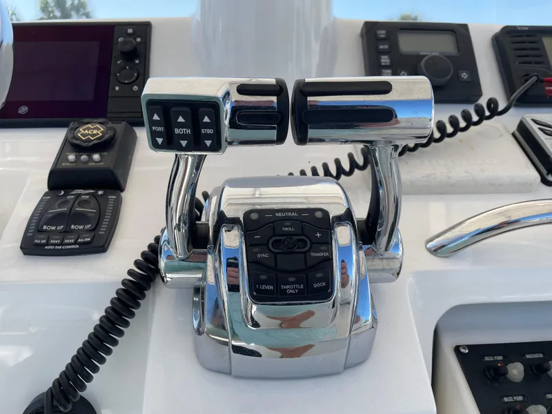 Slide: The Image of Control panel of a 2008 Intrepid 323 Cuddy boat with throttle levers and navigation equipment. - 35