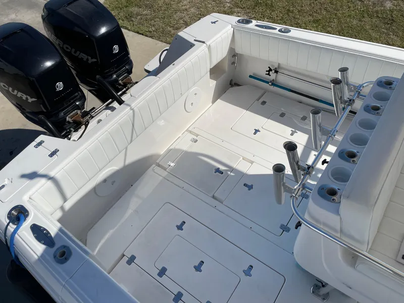 Slide: The Image of 2008 Intrepid 323 Cuddy boat deck with dual Mercury outboard engines and rod holders. - 44