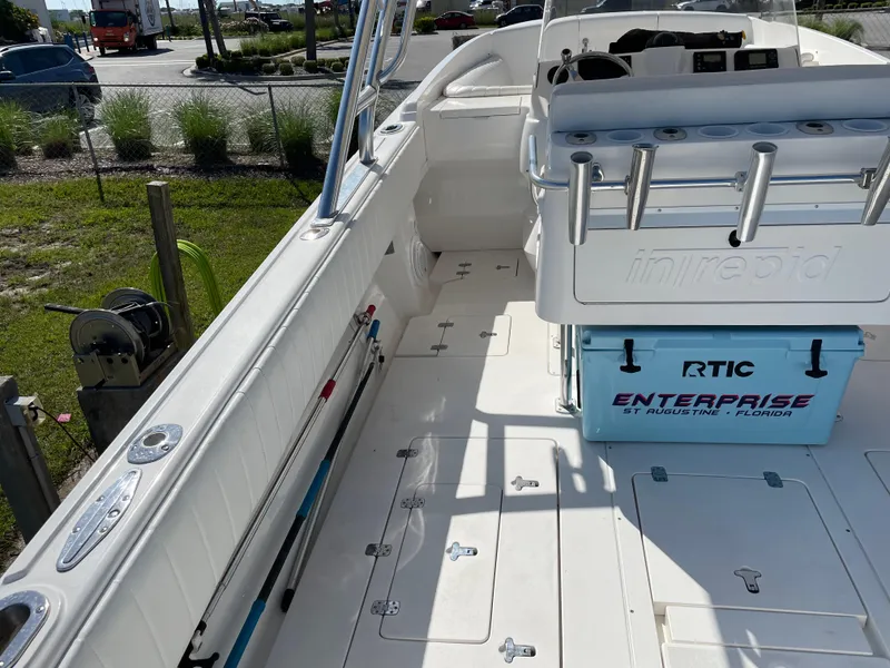 Slide: The Image of 2008 Intrepid 323 Cuddy boat deck with seating and storage, docked outdoors. - 46