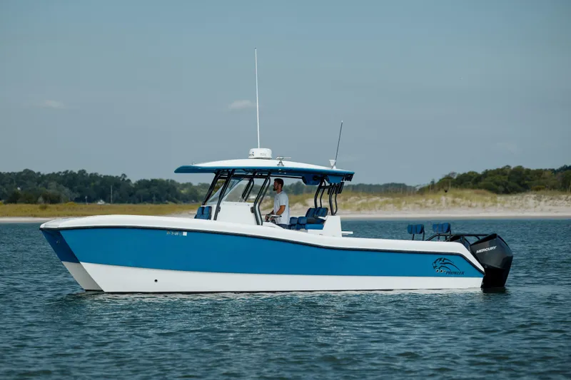 Slide: The Image of 2020 Prowler 31 boat on calm water, blue and white design, side view. - 1