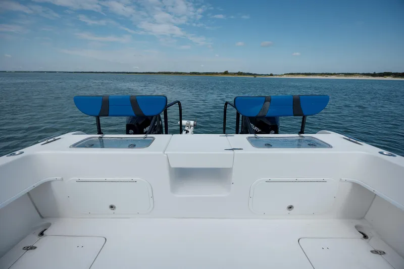 Slide: The Image of 2020 Prowler 31 boat deck with dual engines, overlooking calm waters and clear sky. - 10