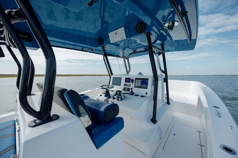 Slide: The Image of 2020 Prowler 31 boat interior with modern controls and blue accents on open water. - 15