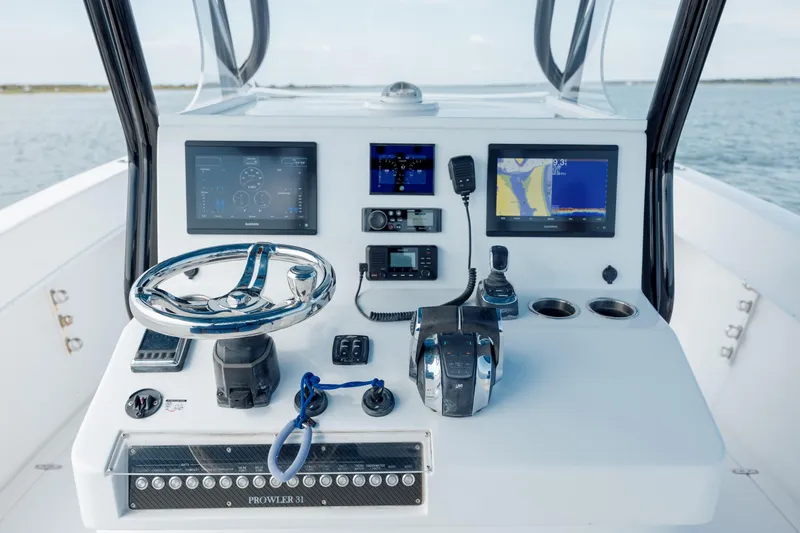 Slide: The Image of Control panel of a 2020 Prowler 31 boat with navigation screens and steering wheel. - 17