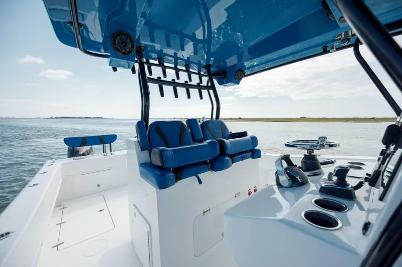 Slide: The Image of 2020 Prowler 31 boat interior with blue seating and control panel on open water. - 19
