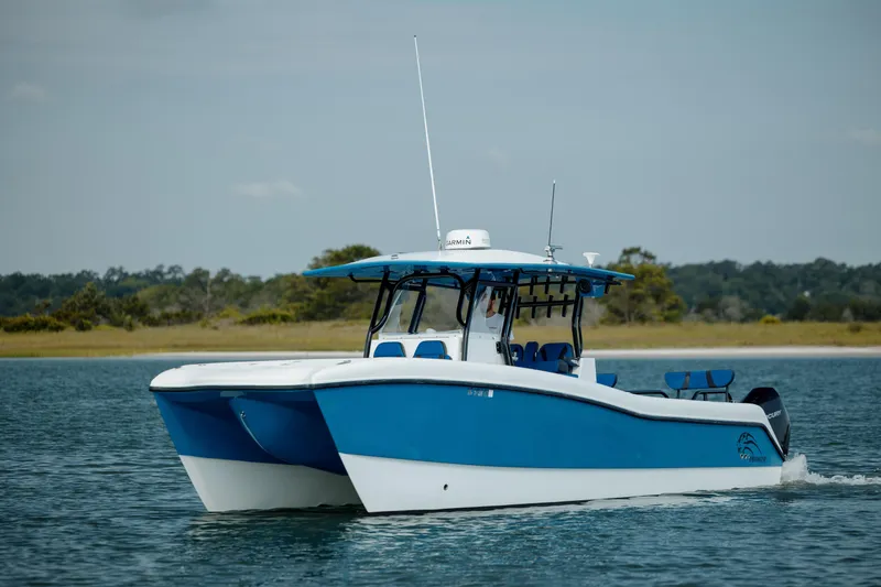 Slide: The Image of 2020 Prowler 31 boat cruising on calm water, featuring a sleek blue and white design. - 2