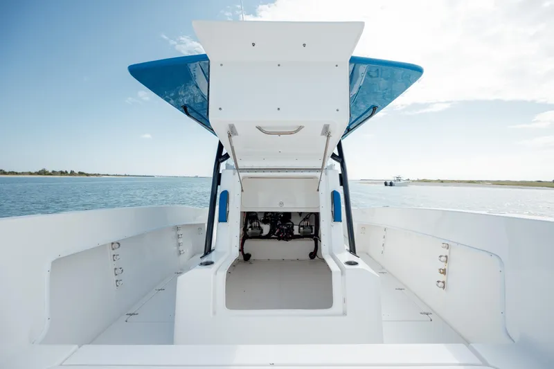 Slide: The Image of 2020 Prowler 31 boat interior with open deck and blue canopy on calm water. - 24