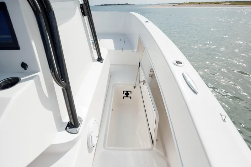 Slide: The Image of 2020 Prowler 31 boat deck with storage compartment, near calm waters. - 28