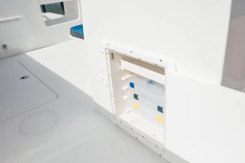 Slide: The Image of 2020 Prowler 31 boat storage compartment with tackle boxes. - 32