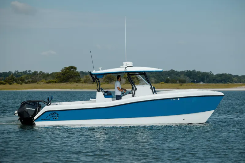 Slide: The Image of 2020 Prowler 31 boat on calm water, featuring a sleek blue and white design. - 5