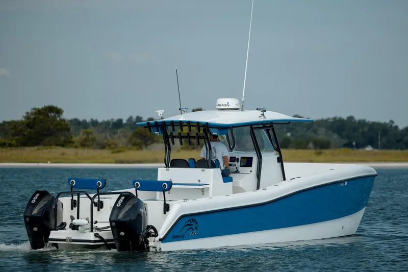 Slide: The Image of 2020 Prowler 31 boat with dual outboard motors cruising on calm water. - 6