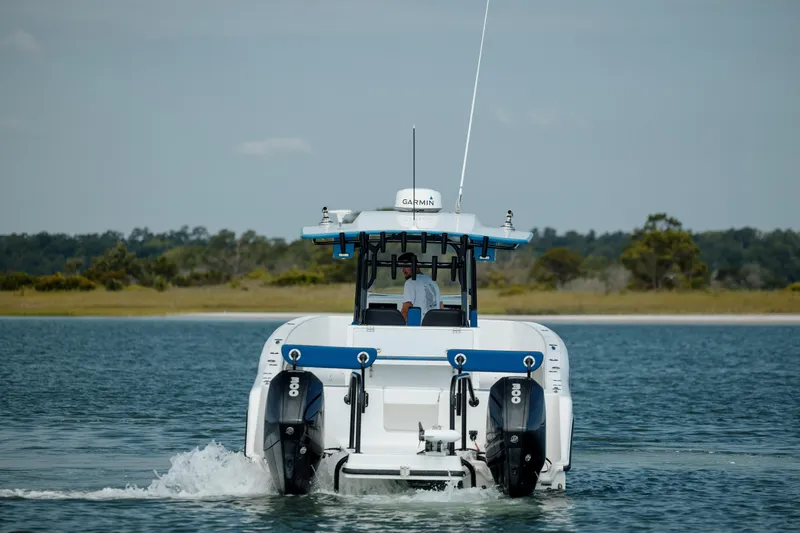 Slide: The Image of 2020 Prowler 31 boat cruising on water with twin engines, scenic background. - 7