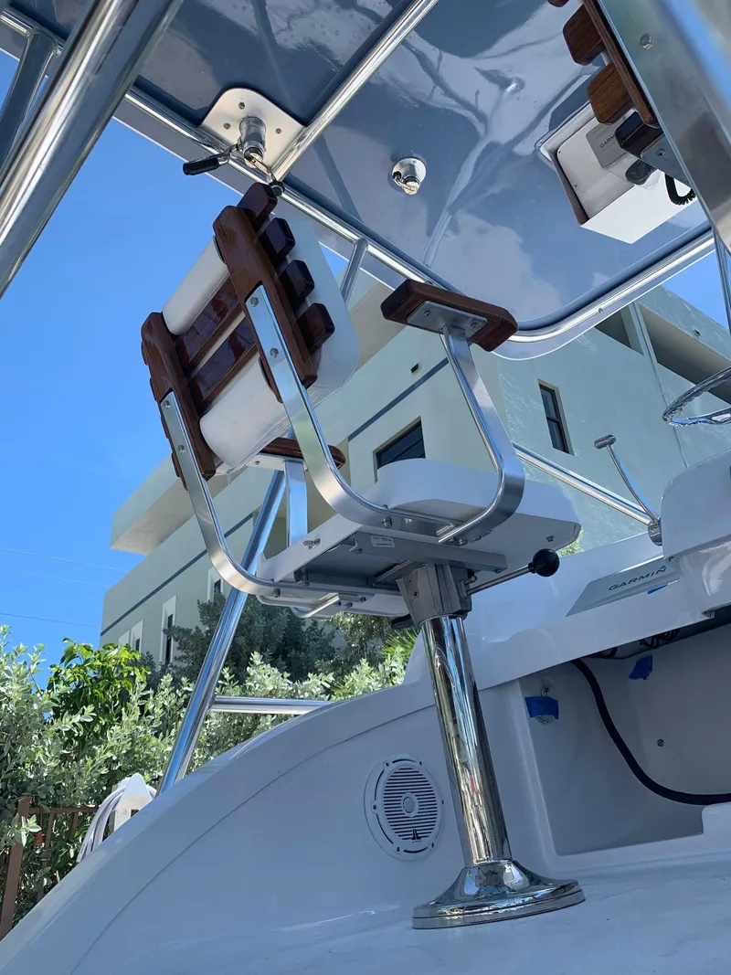 Slide: The Image of 1974 Bertram 31 Flybridge Cruiser helm seat and controls under blue sky. - 10
